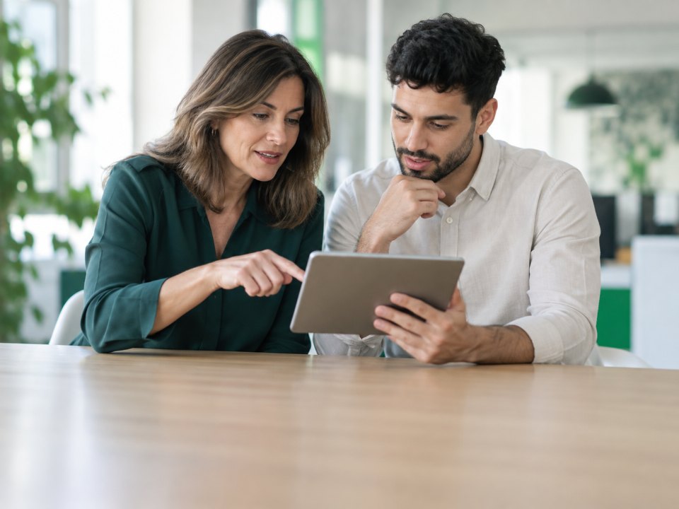 Two colleagues reviewing a loyalty program together on a tablet